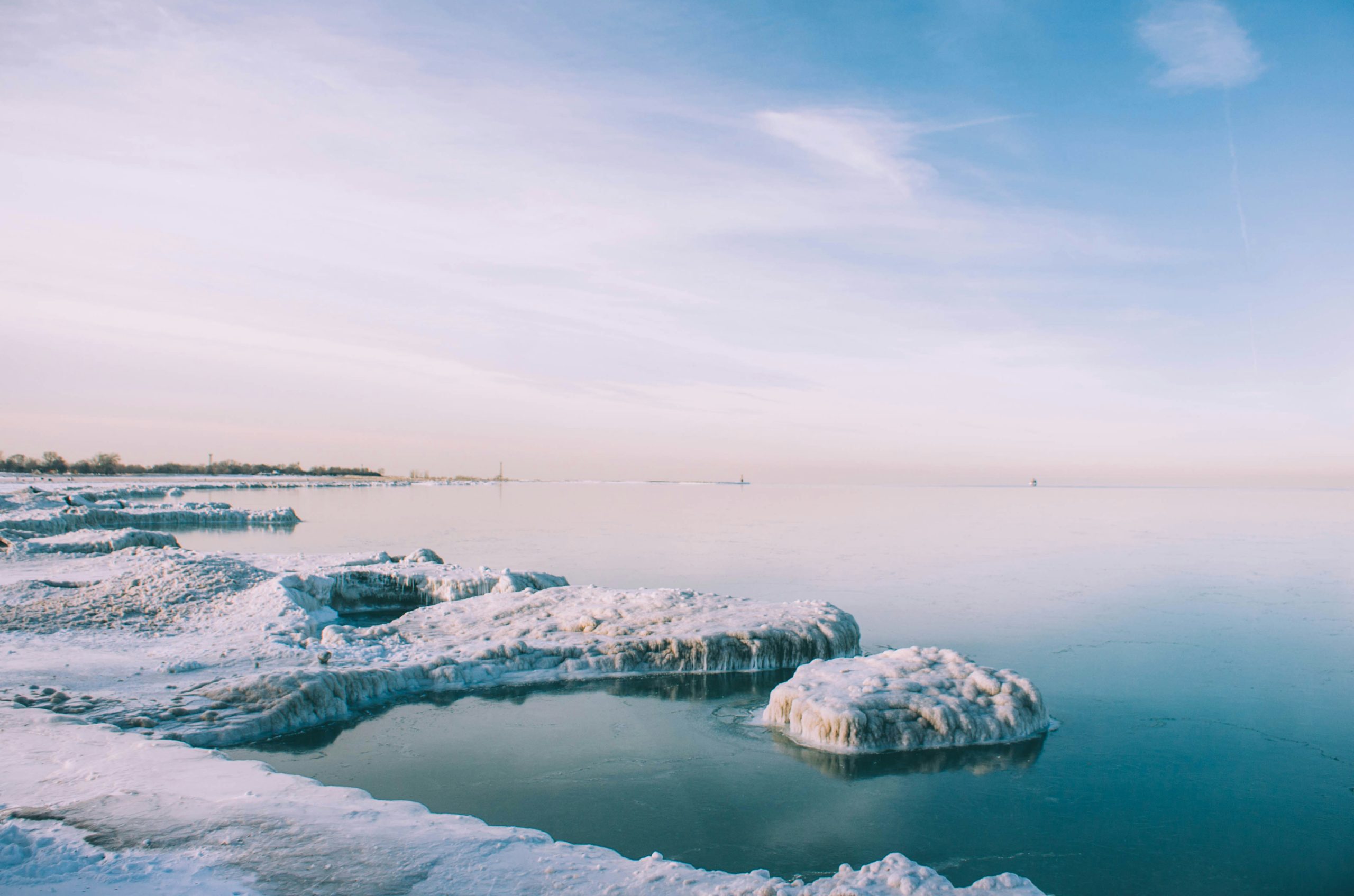 snowfield near body of water view during daytime
