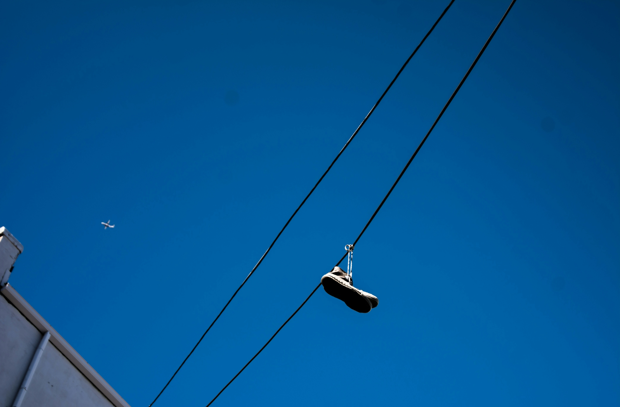 unpaired shoe hanging on cable
