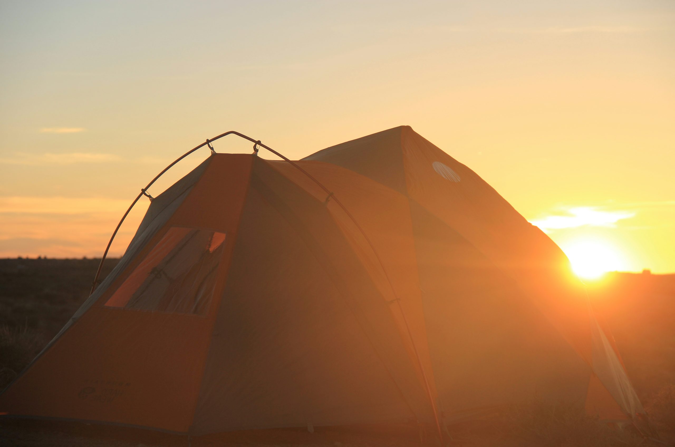 brown tent under gray sky during sunset