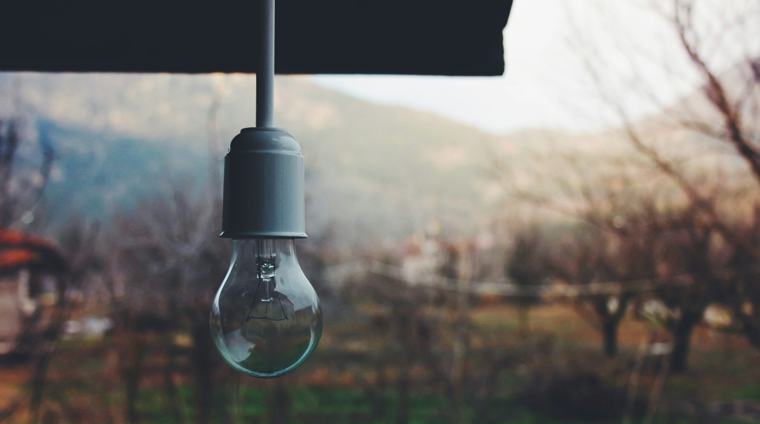 a light bulb hanging from a black umbrella
