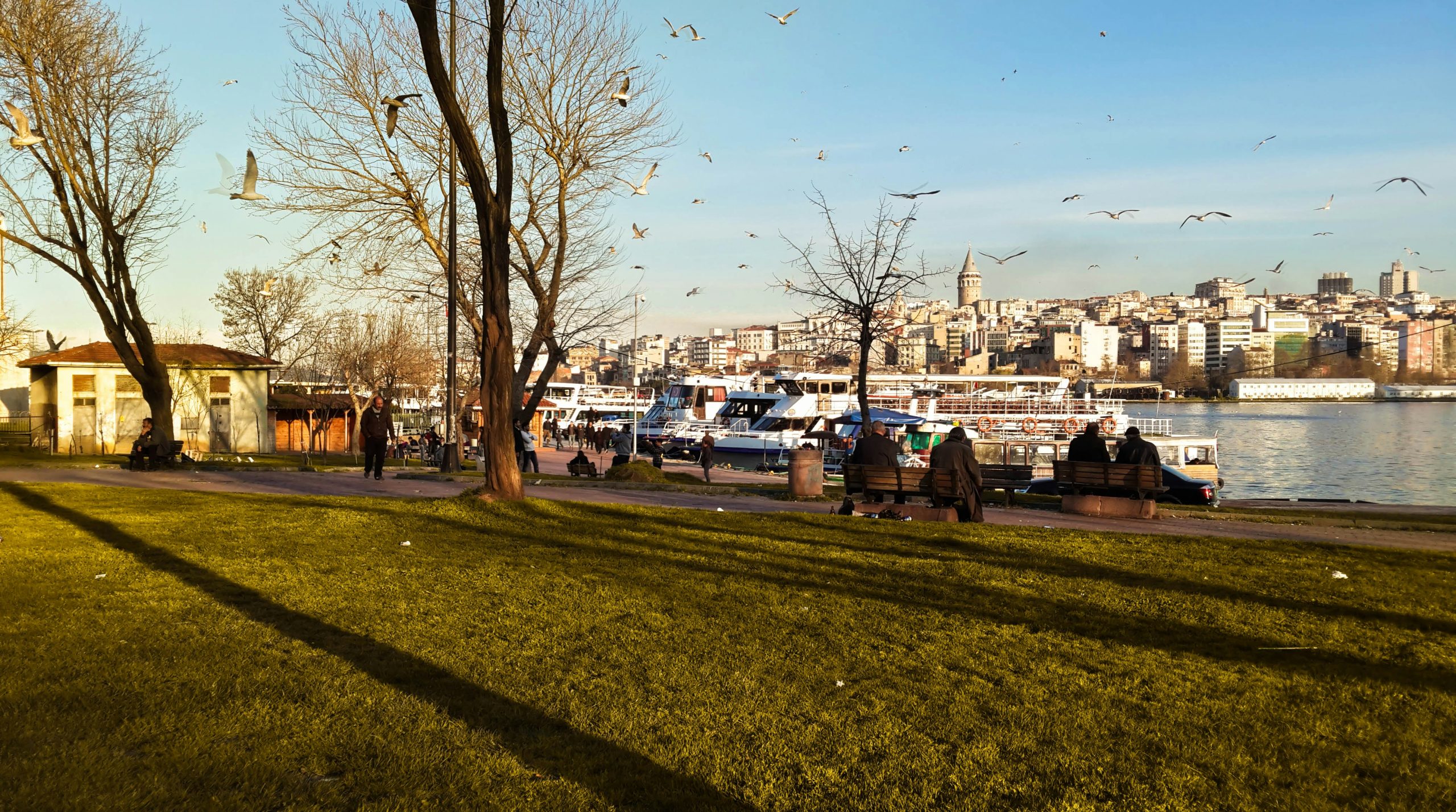 a group of people sitting on a bench next to a river